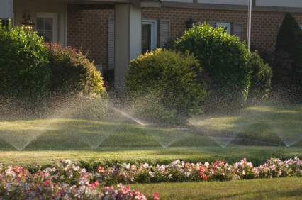 Residential Irrigation: Sprinklers watering a home lawn.